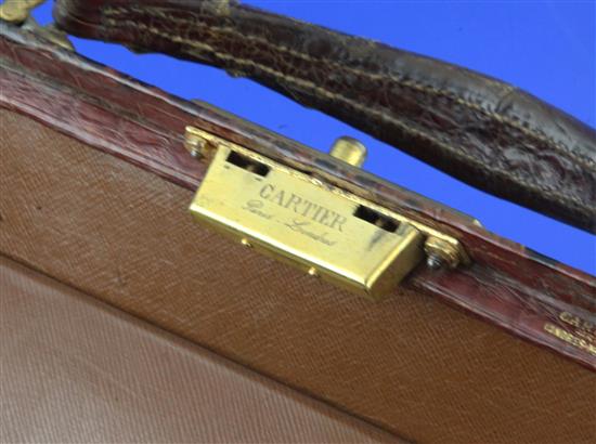 An early 20th century Cartier gilt metal mounted crocodile skin Doctors travelling toilet case